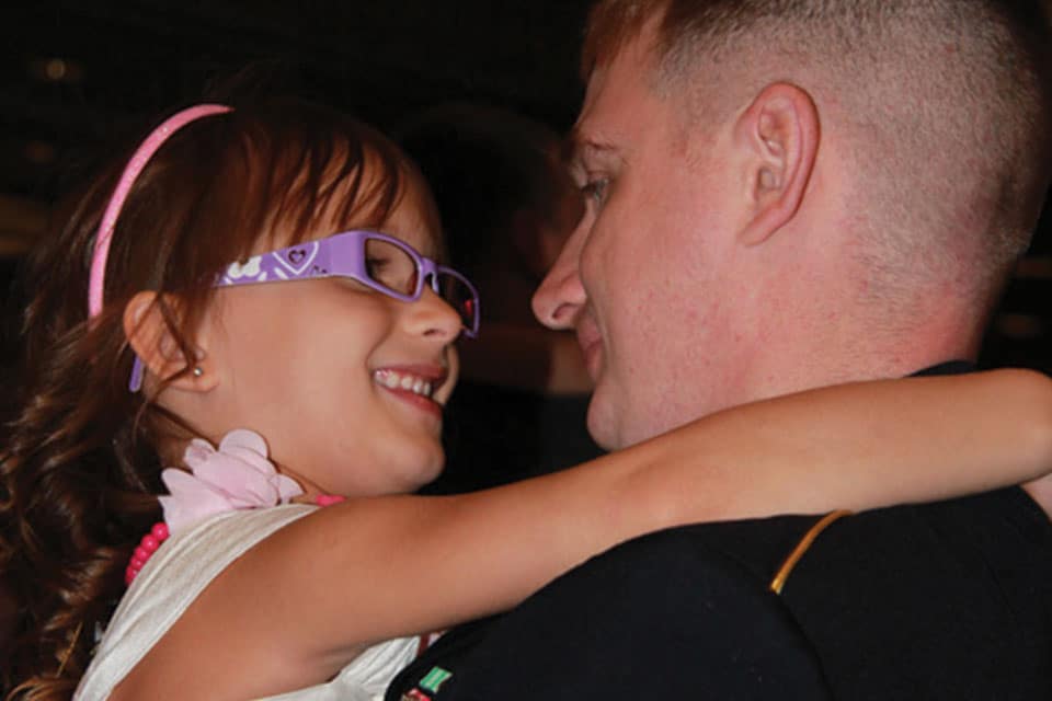 Father and his daughter smiling suring a dance together